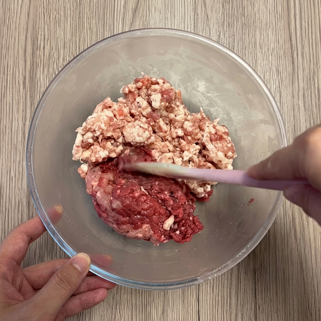 Schweine- und Rinderhackfleisch in einer klaren Schüssel.