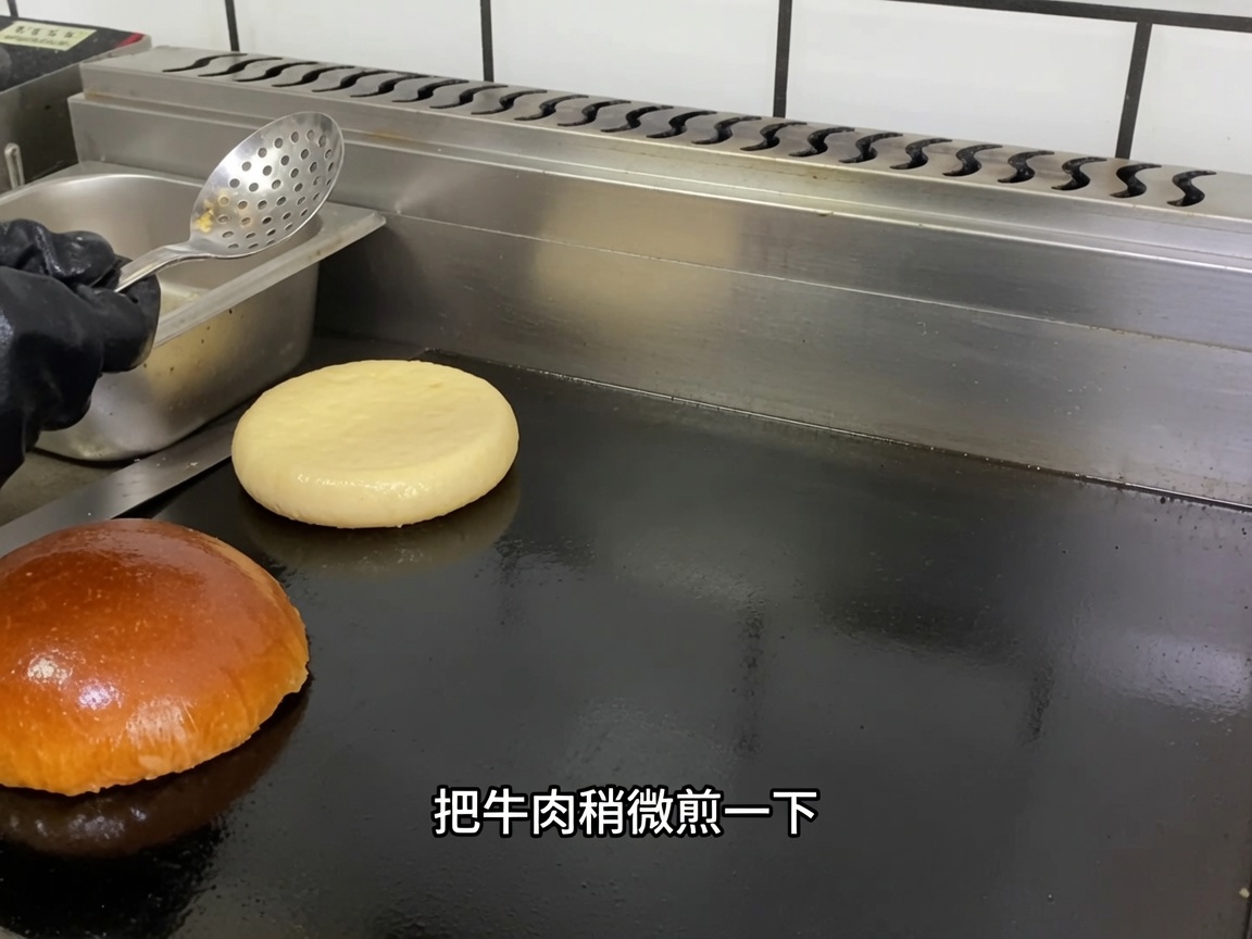 Ein rohes Rinder-Patty liegt auf der heißen Grillplatte.