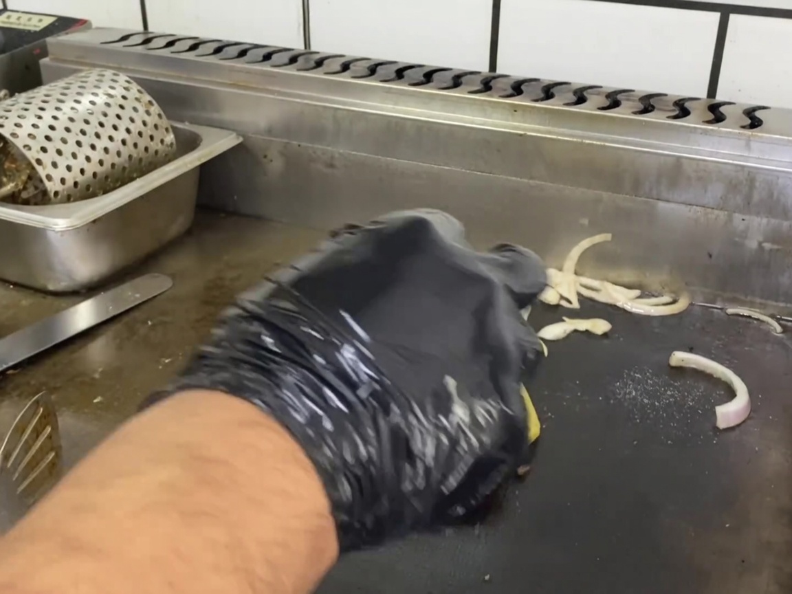 Ein gebräuntes Rinder-Patty mit einer geschmolzenen Käsescheibe darauf.