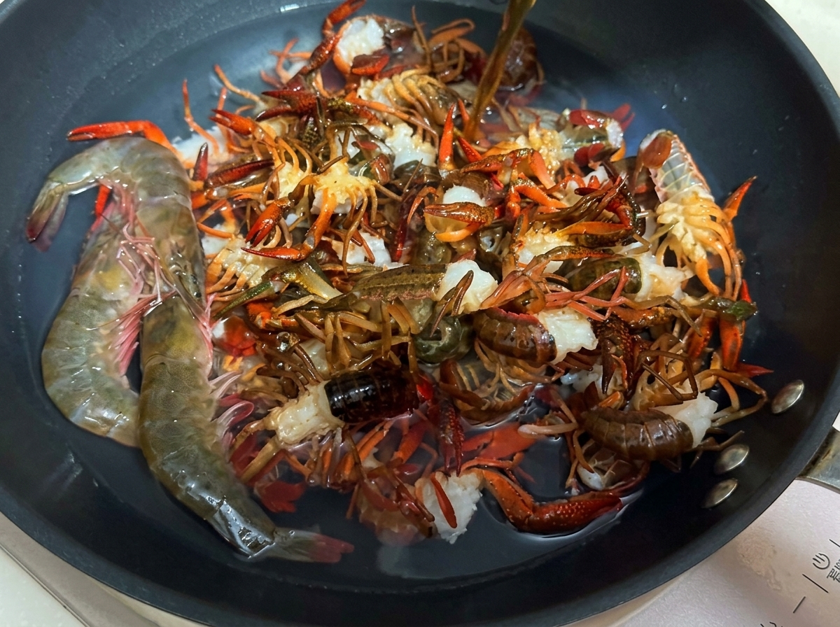 Frische Flusskrebse werden in einer Pfanne mit Wasser und Kochwein blanchiert.