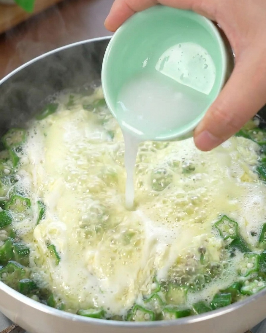 Stärkewasser wird in die blubbernde Okra-Eierstichsuppe gegossen und dickt die Brühe an.