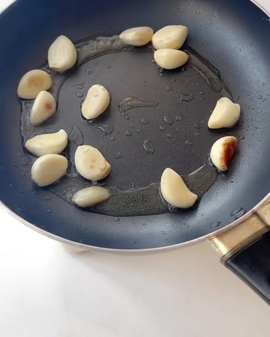 Speckstreifen braten zusammen mit dem Knoblauch in der Pfanne.