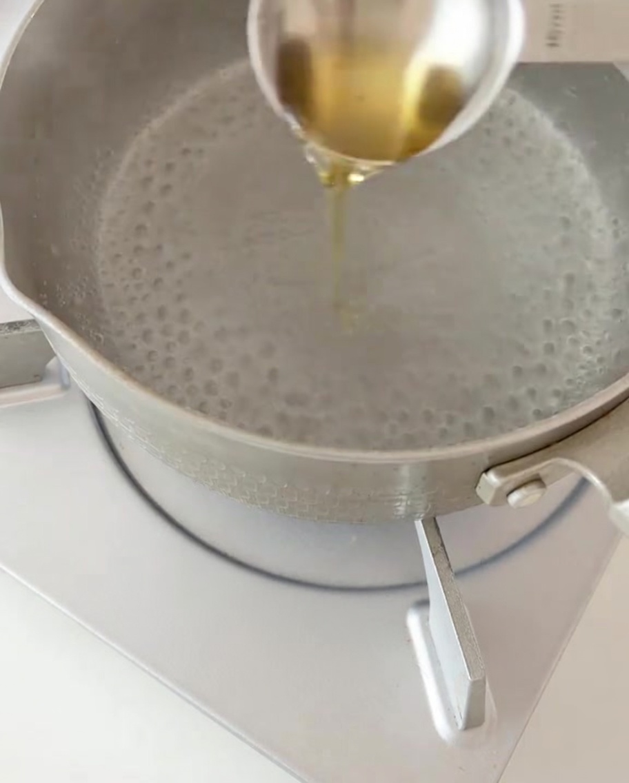 Trockene Fusilli-Nudeln werden in einen Topf mit kochendem Wasser und einem Schuss Öl gegeben.