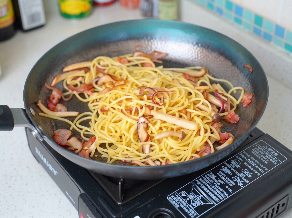 Milch wird über die Pasta-Mischung in der Pfanne gegossen.