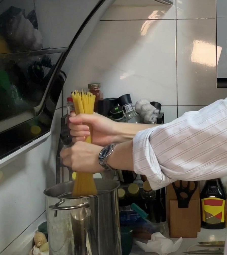 Spaghetti werden in einen Topf mit kochendem Wasser mit Öl und Salz gegeben.