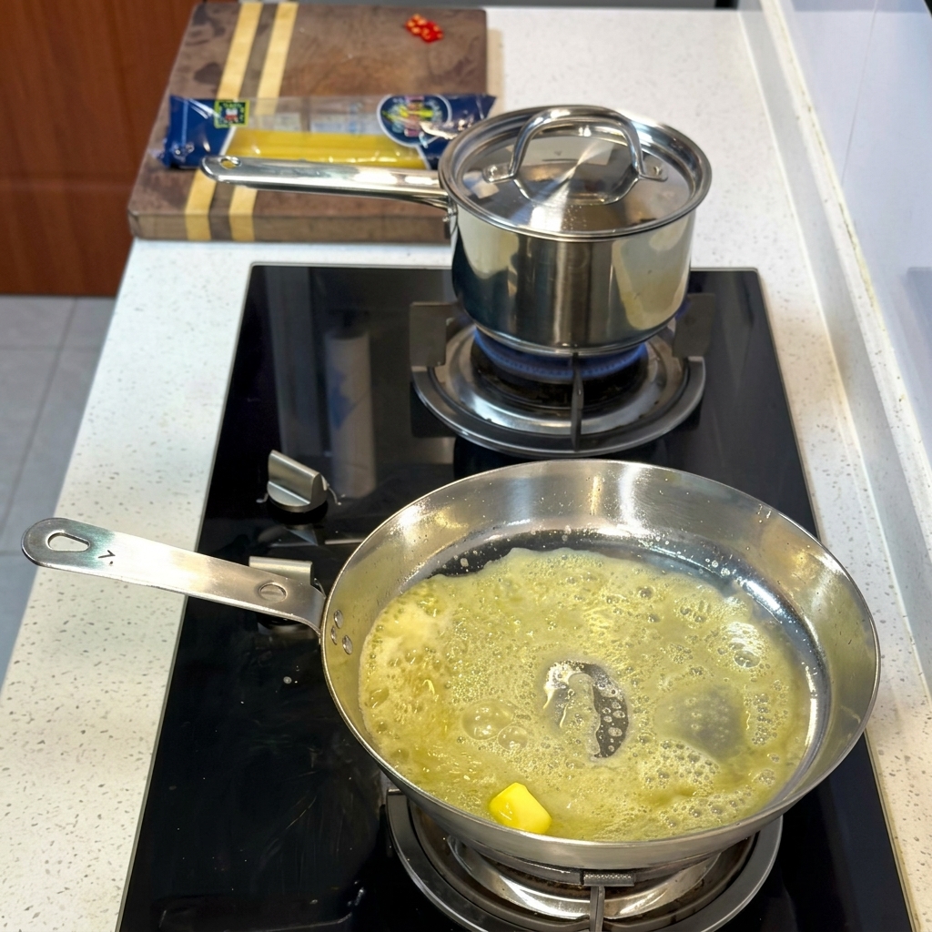 Garnelen und Jakobsmuscheln, die in der Butter-Öl-Mischung angebraten werden.