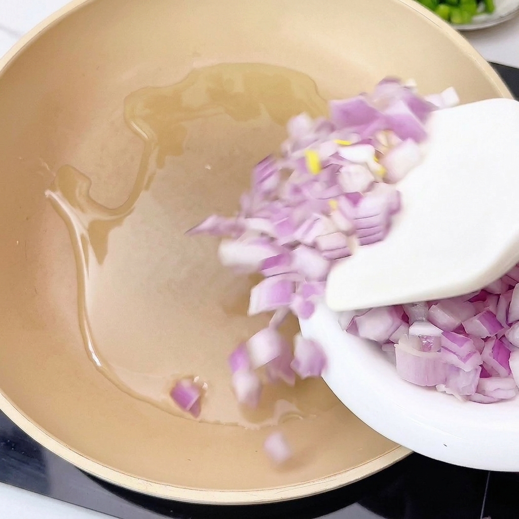 Zwiebeln und Knoblauch werden in einer Pfanne in heißem Öl angebraten.