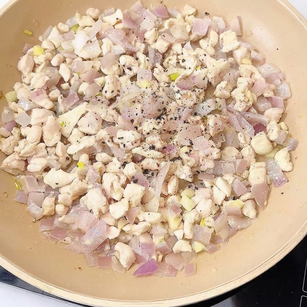 Hähnchen-Pfannengericht wird mit verschiedenen Gewürzen und Saucen abgeschmeckt.