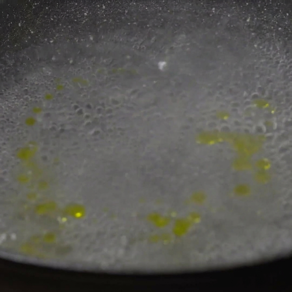 Getrocknete Paccheri-Nudeln werden in einen Topf mit sprudelnd kochendem Wasser gegeben.