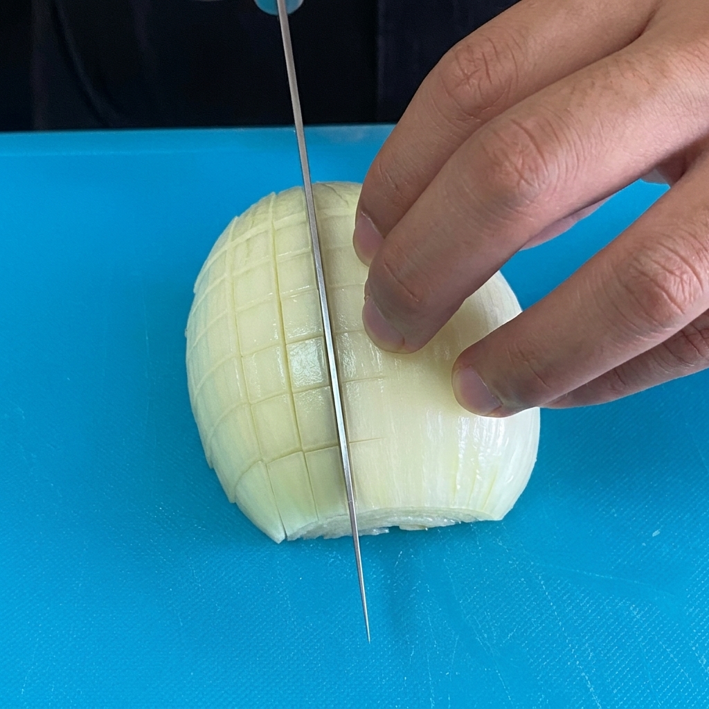 Fein gewürfelte Zwiebelstücke auf einem blauen Schneidebrett.