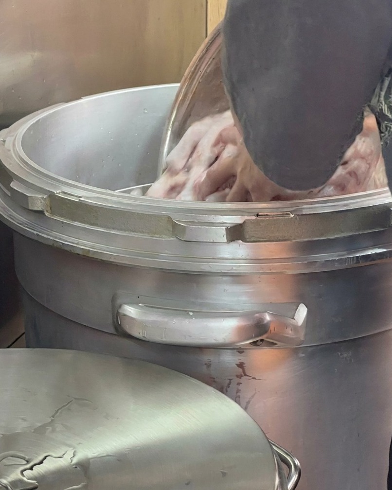 Frisches Wasser wird über die Knochen in einem großen Suppentopf gegossen.