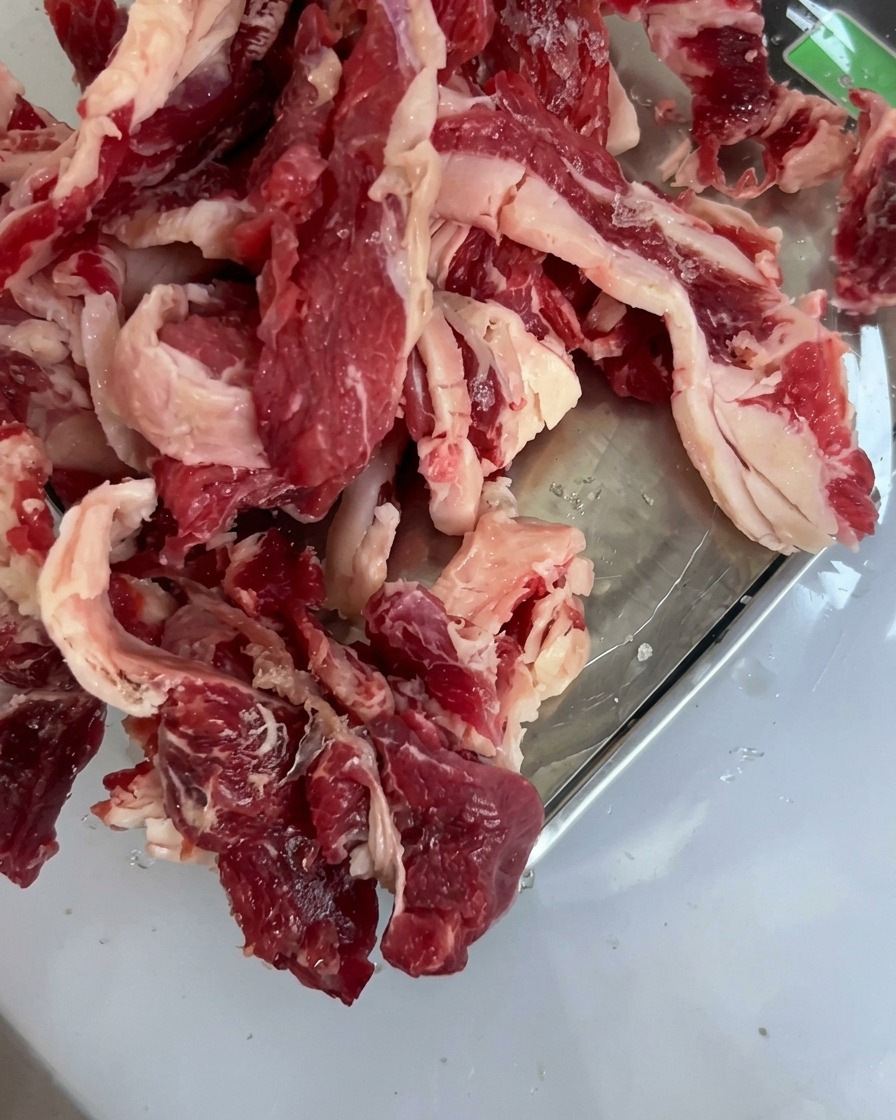 Frische Rindernackenstücke, ordentlich in einem Edelstahltablett angerichtet.