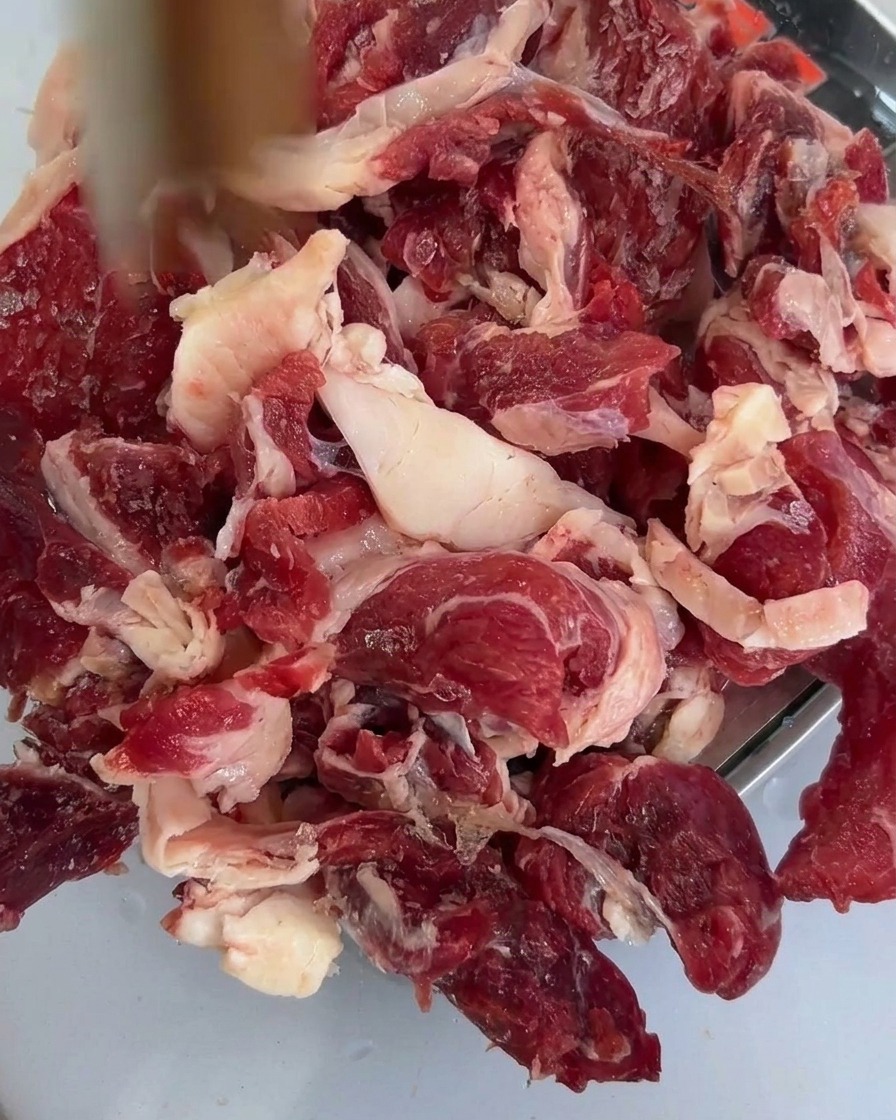 Frisch geschnittene Shiitake-Pilze auf dem rohen Rindfleisch in einer Schale.