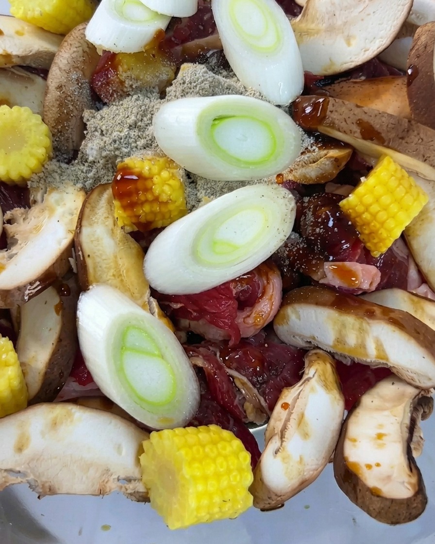 Frische Frühlingszwiebelringe auf der marinierten Mischung.