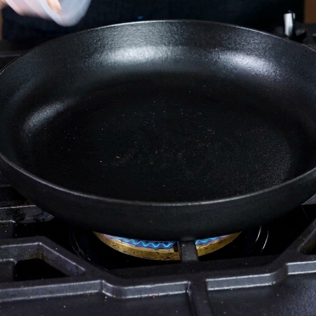 Gewürfelte Speckstücke, die in einer heißen gusseisernen Pfanne braten.