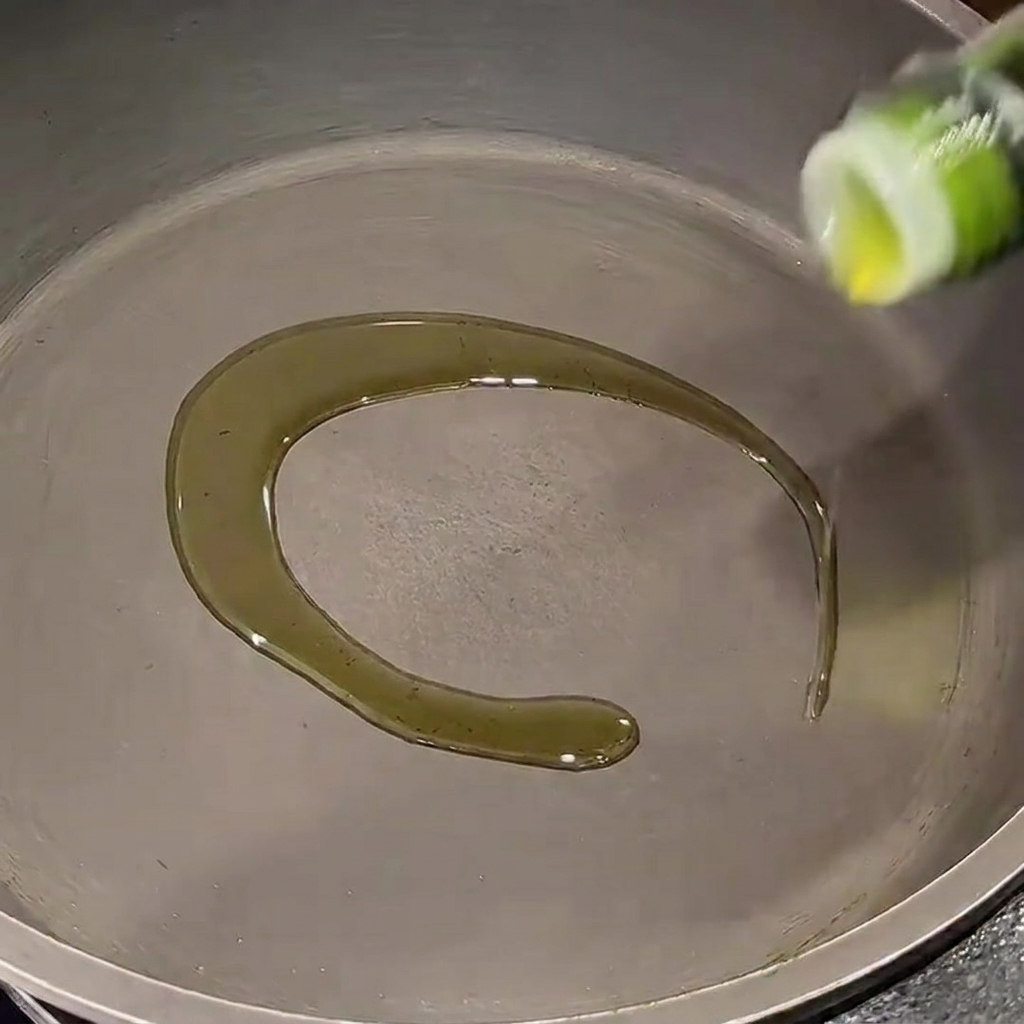 Gehackte rote Zwiebeln, die in einer Pfanne mit Olivenöl glasig gedünstet werden.