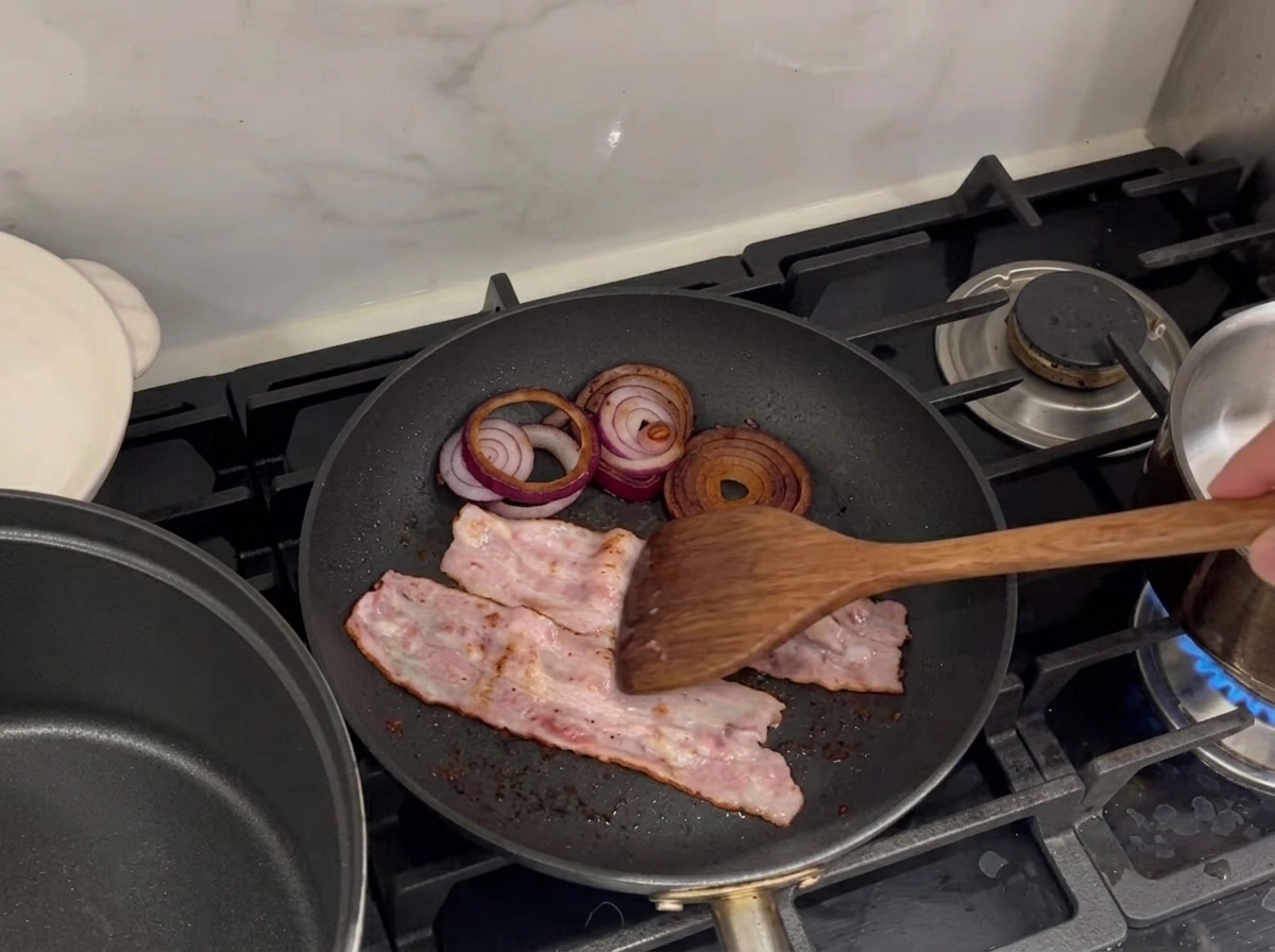 Speckstreifen und Zwiebelringe braten in einer heißen Pfanne.
