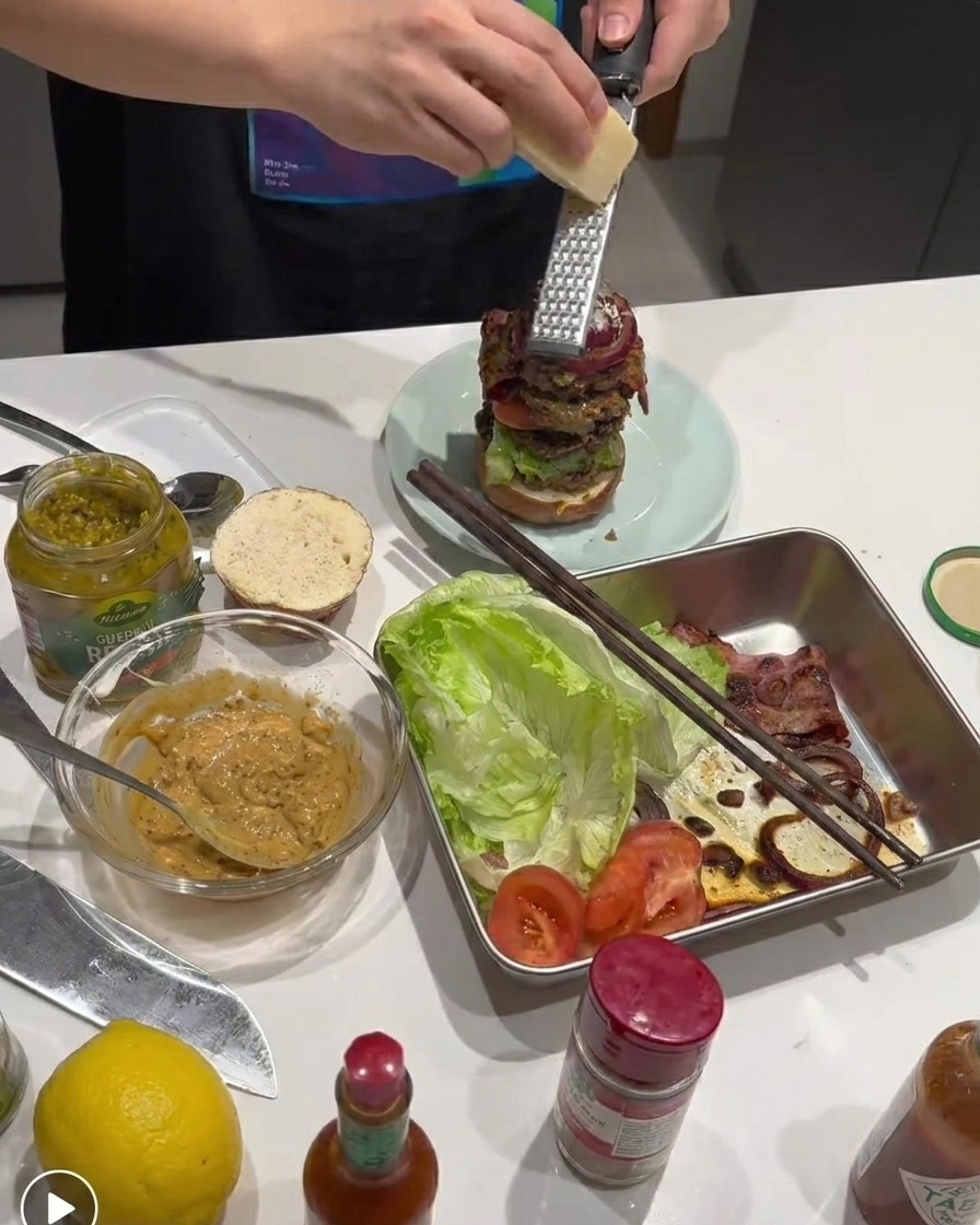 Frischer Parmesan wird über den Burger gerieben.