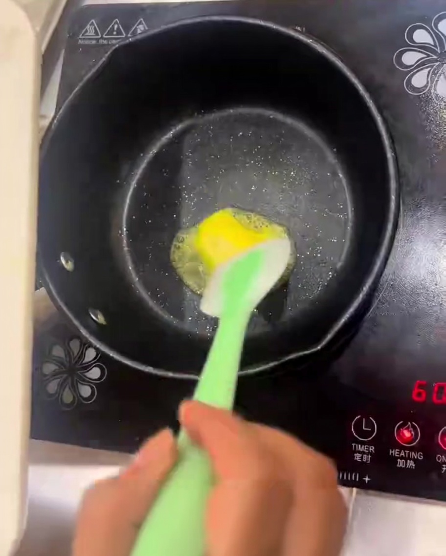 Butter schmilzt in einer Pfanne, in der Zwiebeln und Pilze angebraten werden.