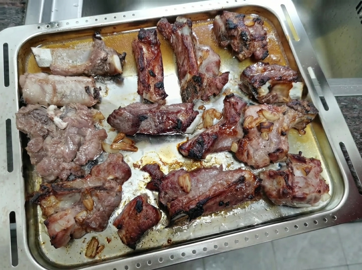 Gebratene, karamellisierte Schweinerippchen auf einem Backblech.