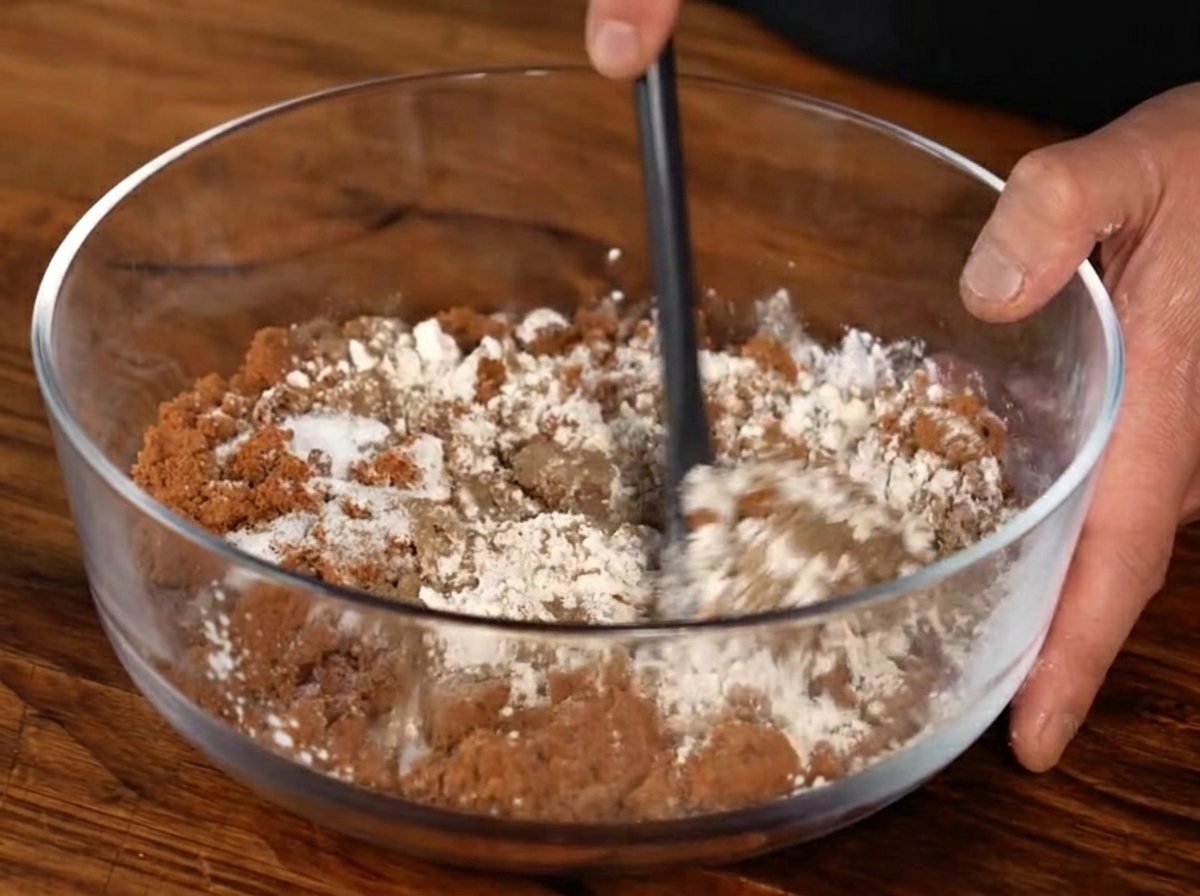 Eine Gewürzmischung aus braunem Zucker, Knoblauchpulver, schwarzem Pfeffer und Salz wird in einer Glasschüssel verrührt.