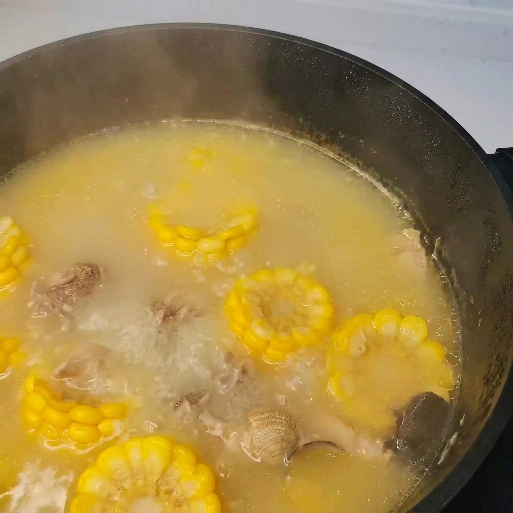 Seetang (Kelp) wird in den Topf mit kochender Suppe aus Schweinefleisch, Muscheln und Gemüse gegeben.
