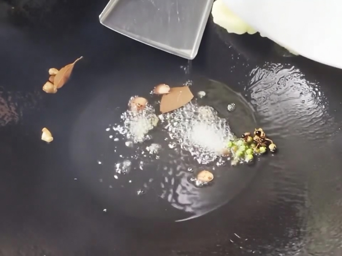 Frisch geschnittene Bambussprossen und Maisstücke werden in einem heißen Wok angebraten.