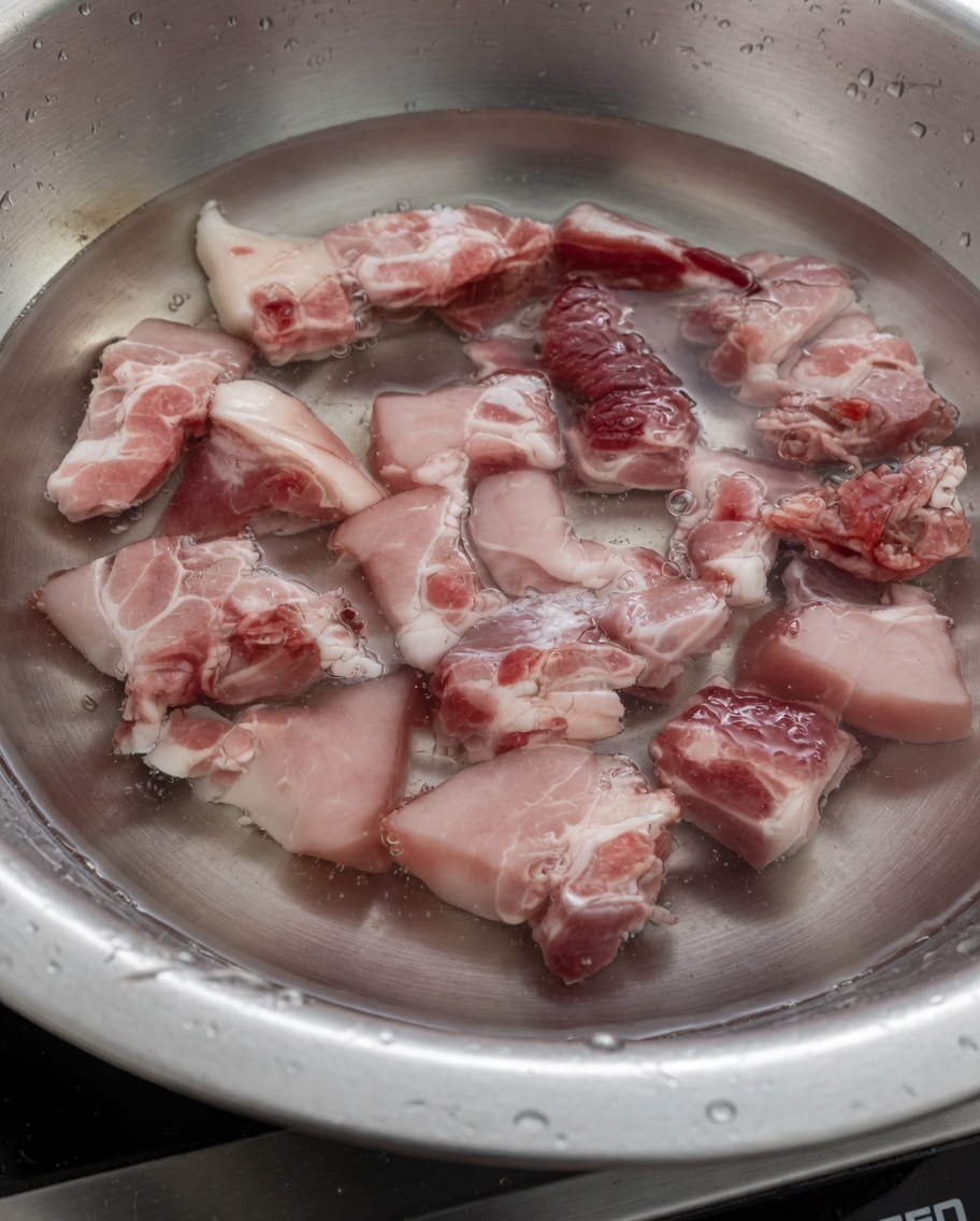 Schweinerippchen kochen in Wasser, um Verunreinigungen zu lösen.
