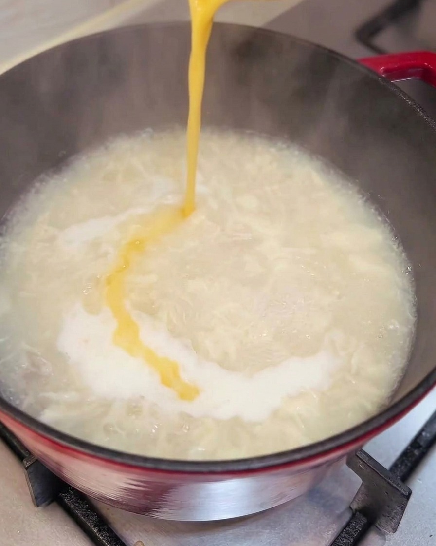 Verquirltes Ei wird in die Suppe gegossen und bildet Eierfäden.