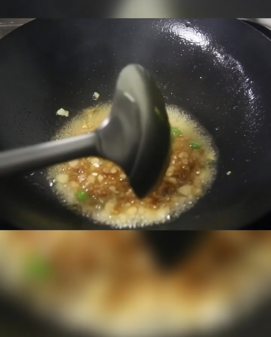 Frühlingszwiebeln, gewürfeltes Fleisch und Kartoffelwürfel braten in einer heißen Pfanne mit Öl.