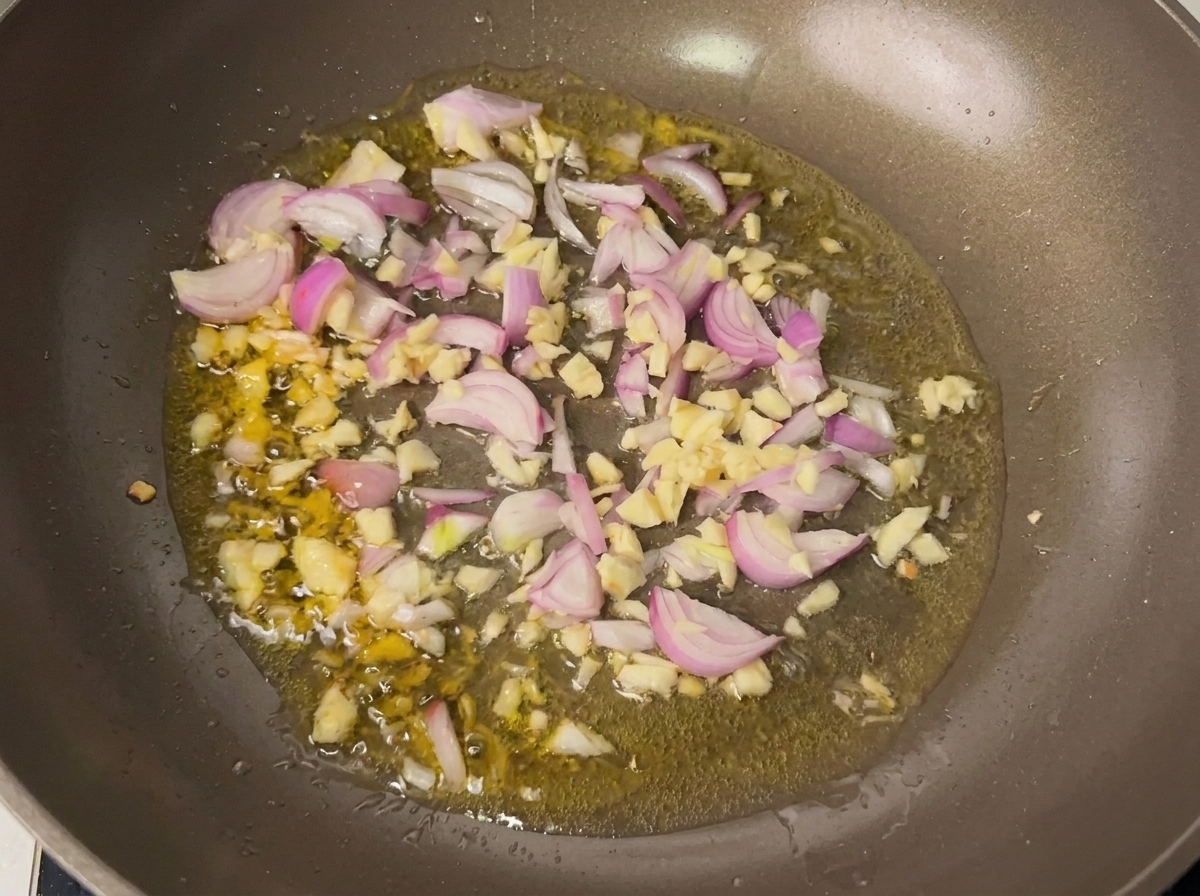 Knoblauch und Schalotten braten in heißem Öl in einer Pfanne.