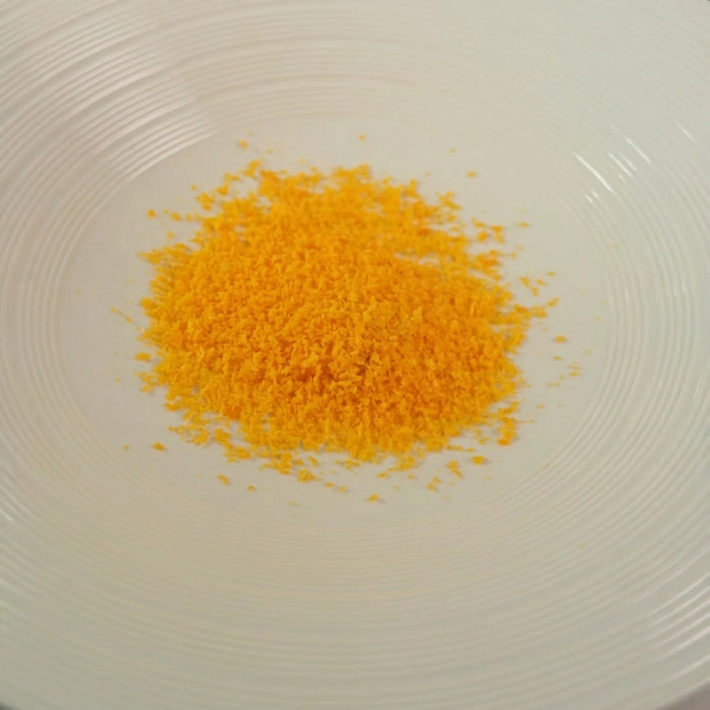 Schüssel mit goldener Mischung aus Bröseln, Kräutern und Käse.