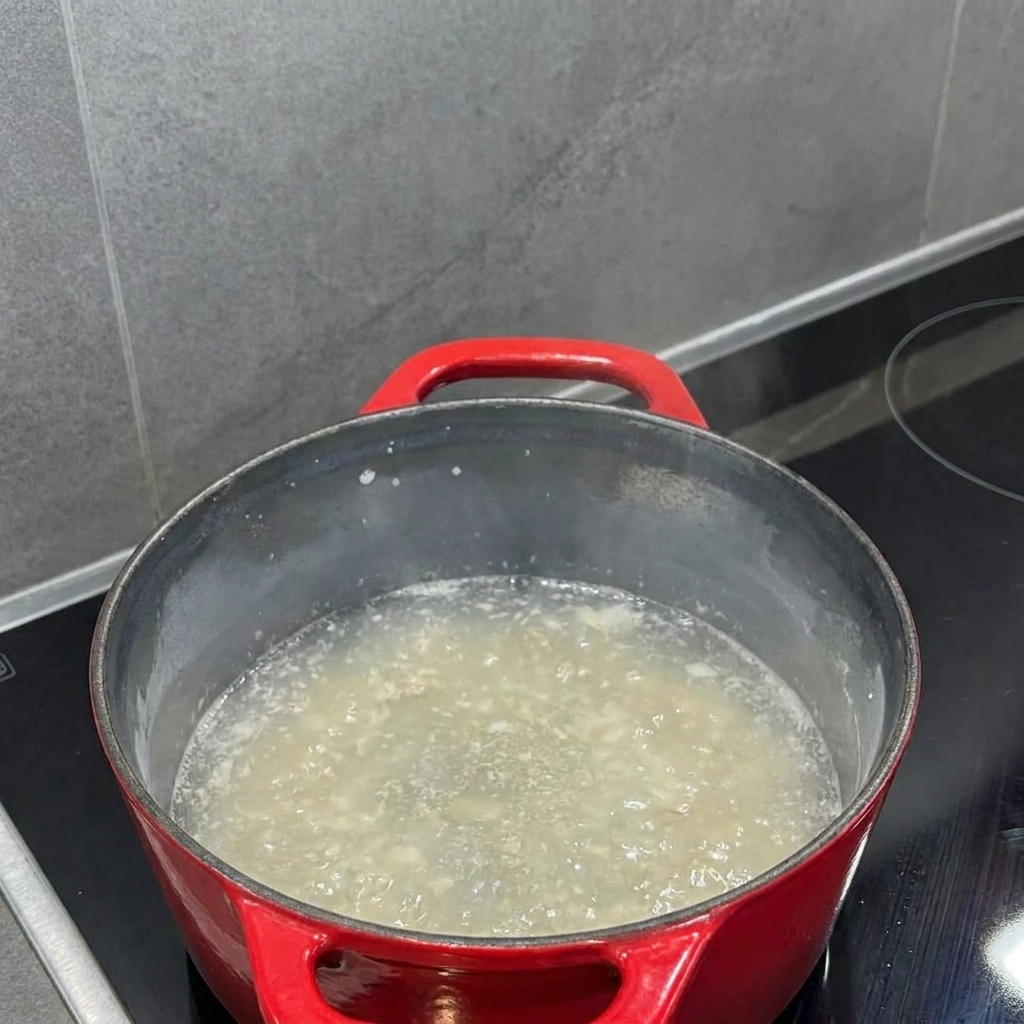 Milch wird in die Mehlschwitze gegossen und zu einer glatten Flüssigkeit verquirlt.