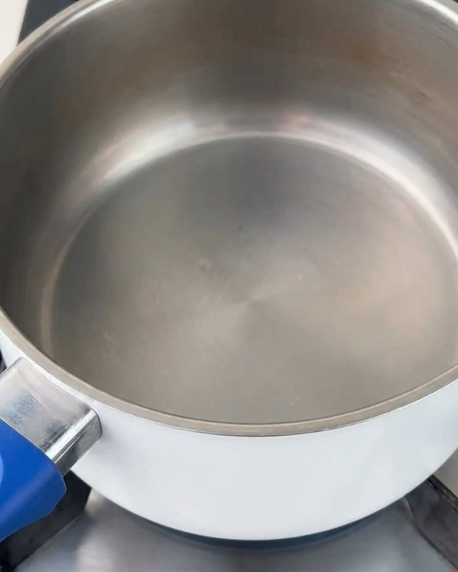 Konzentrierte Tonkotsu-Brühe wird in einen sauberen Topf auf dem Herd gegossen.