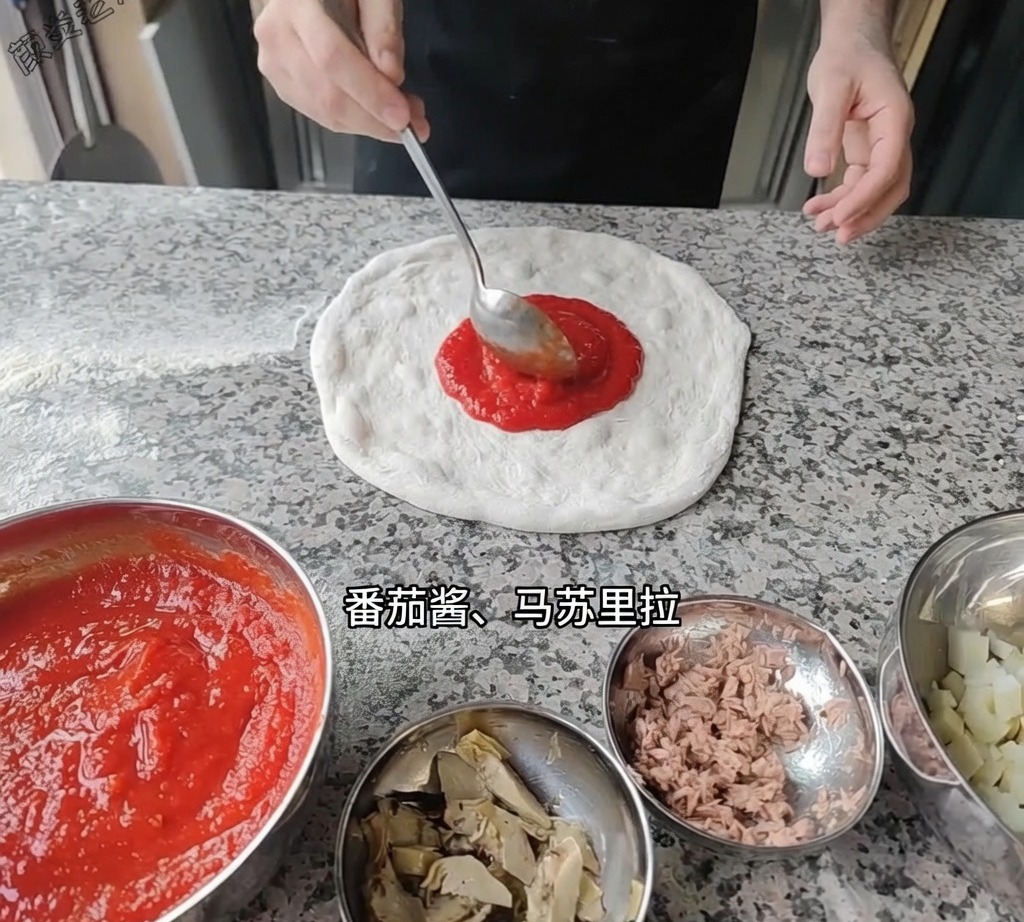 Eine Schöpfkelle verteilt rote Tomatensauce auf dem Pizzateigboden.