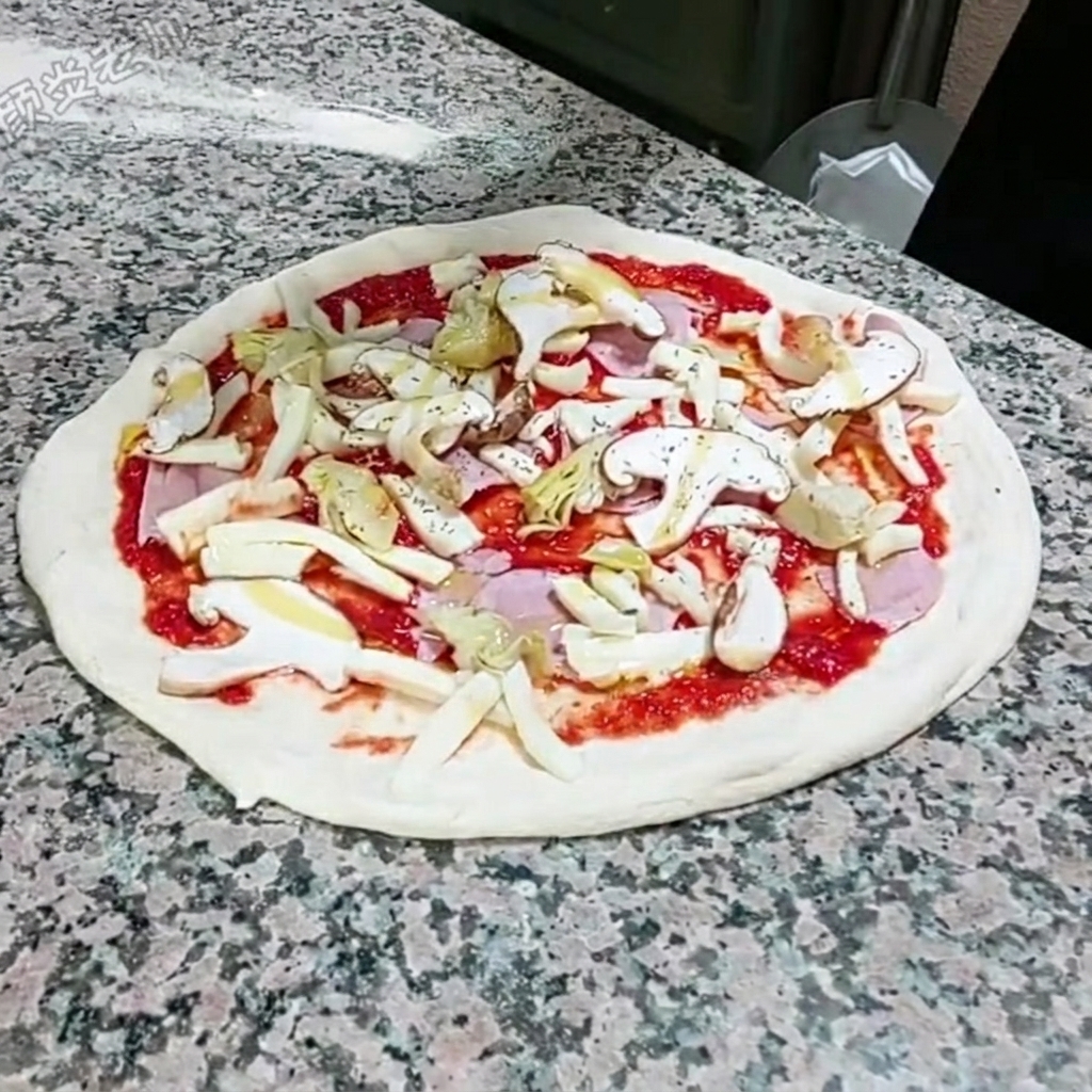 Getrockneter Oregano wird von Hand über die belegte Pizza gestreut.
