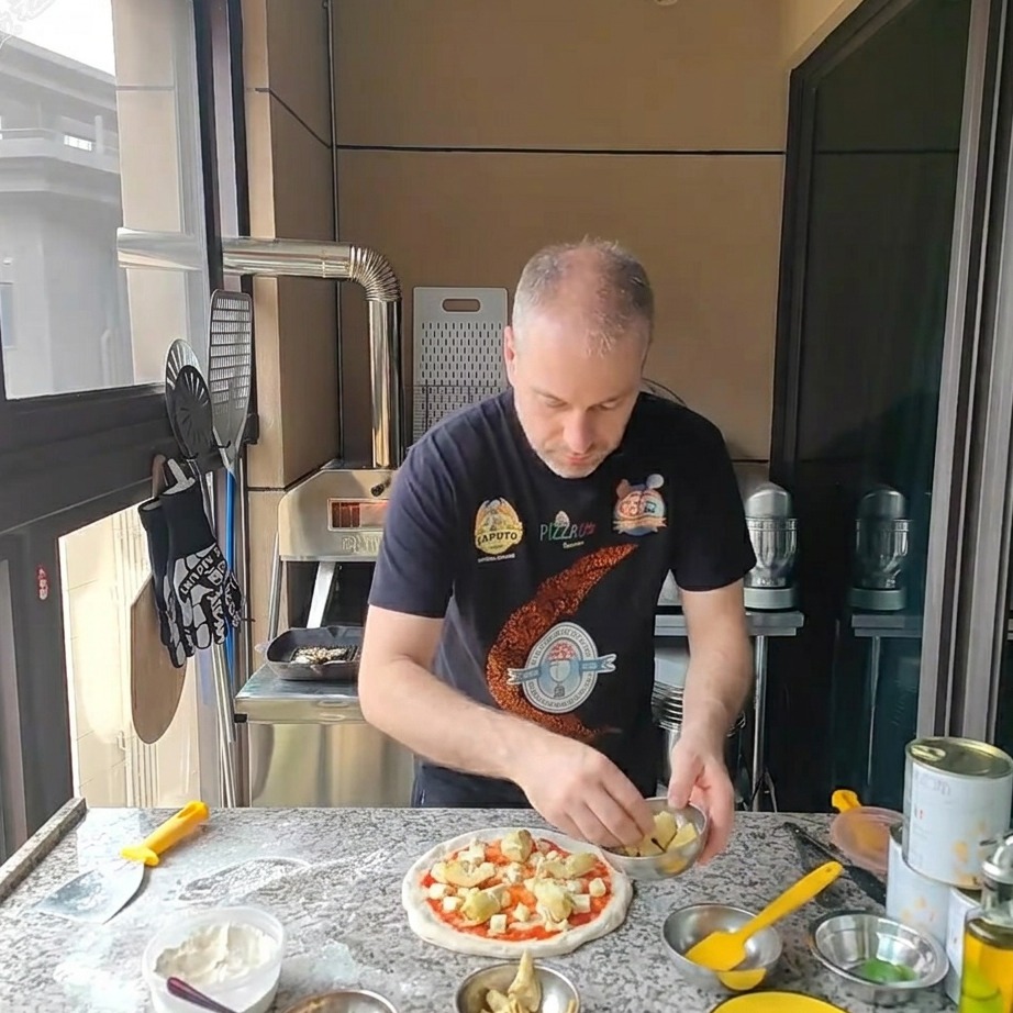 Artischockenstücke aus der Dose werden auf dem Käse platziert.