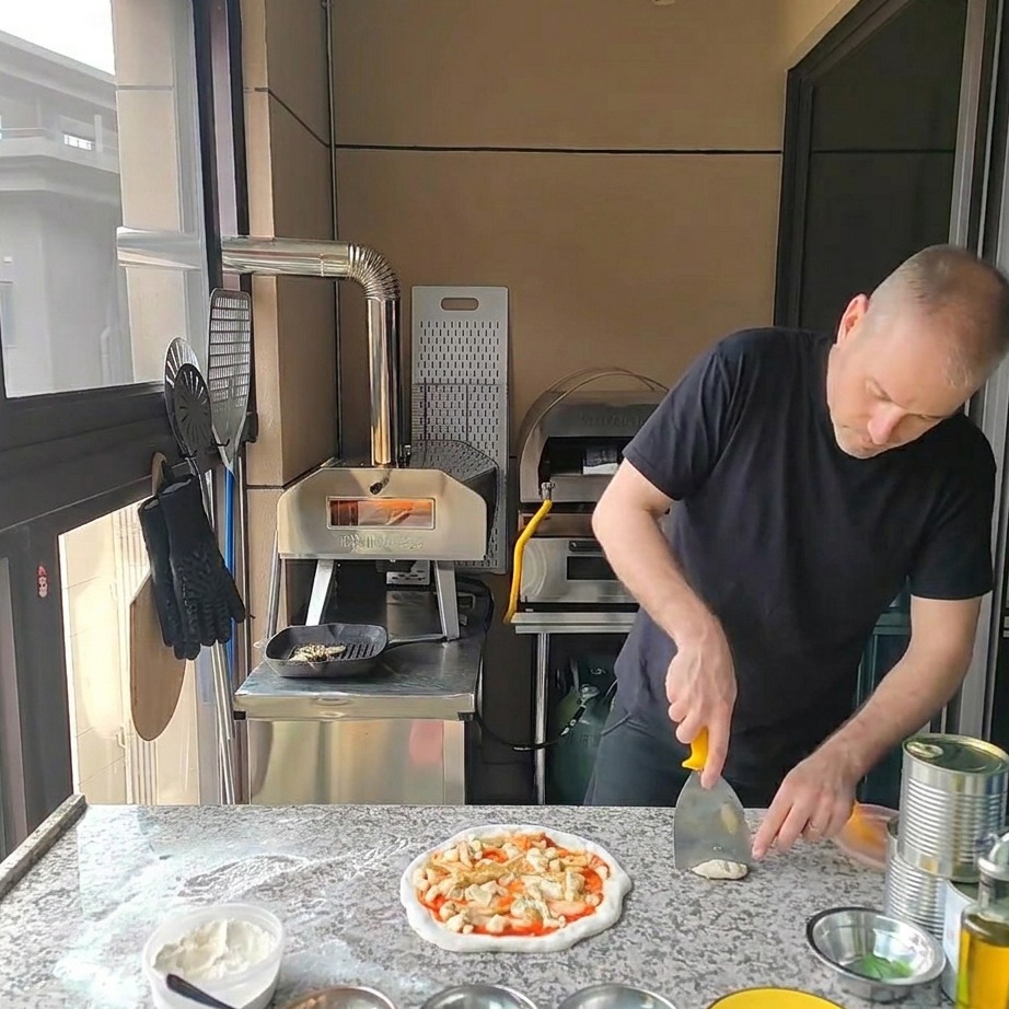 Gegrillte Hähnchenstücke werden auf der Pizza platziert.