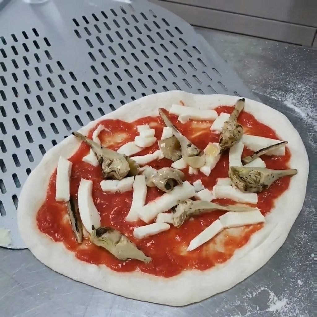Hände justieren die Position der Artischocken auf der Pizza.
