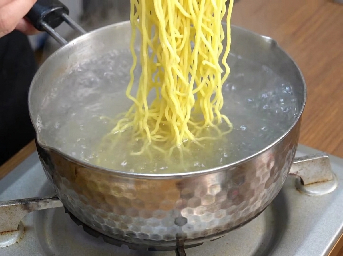 Chinesische Ramen-Nudeln kochen in einem Topf mit Wasser.