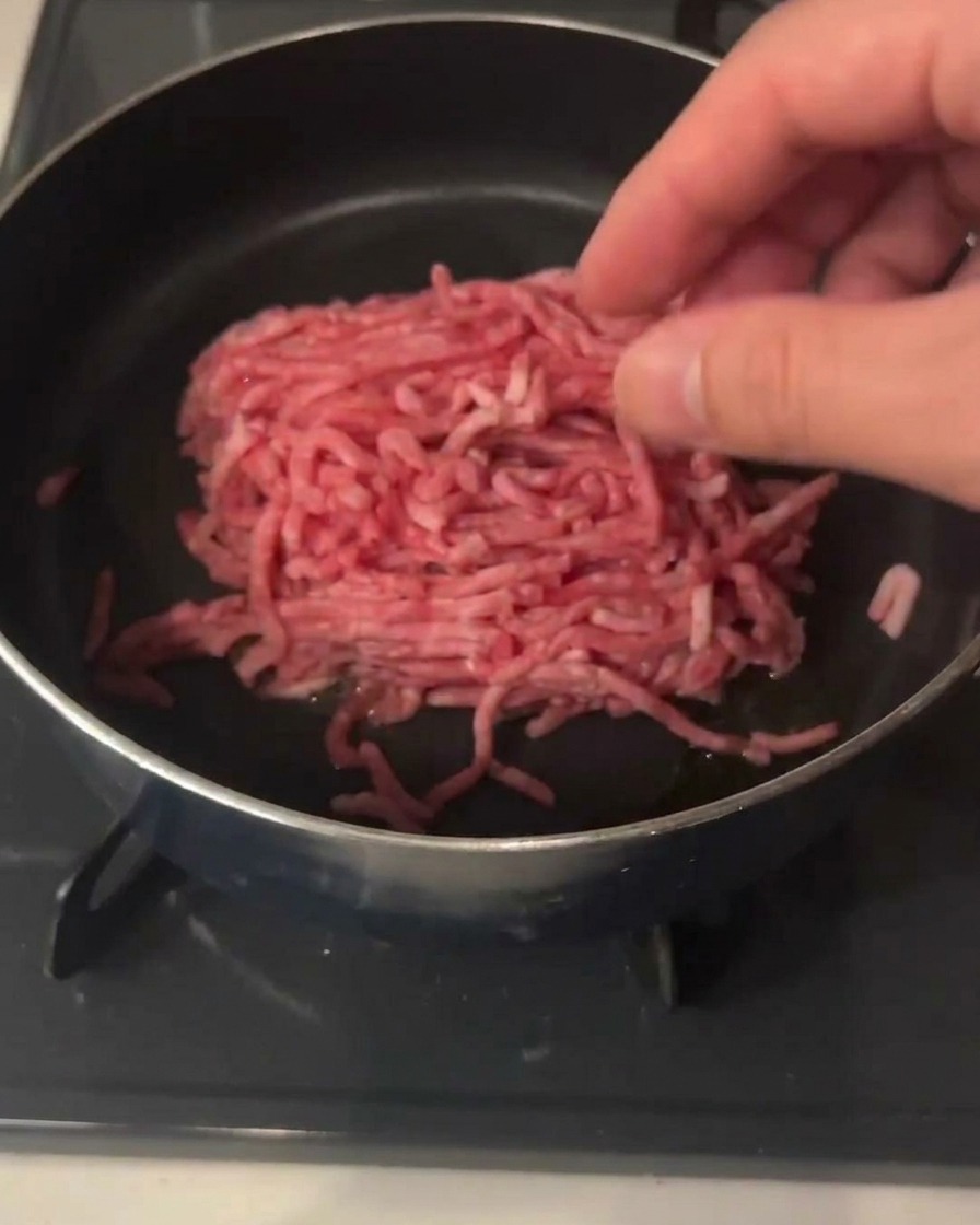 Hackfleisch, ein Klecks scharfe Bohnenpaste und Knoblauchpaste im Topf.
