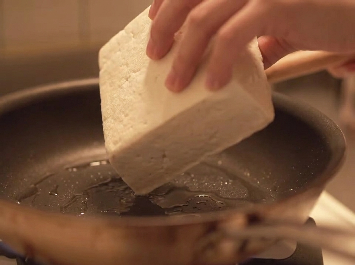 Hackfleisch wird in eine heiße Pfanne mit Öl gegeben.