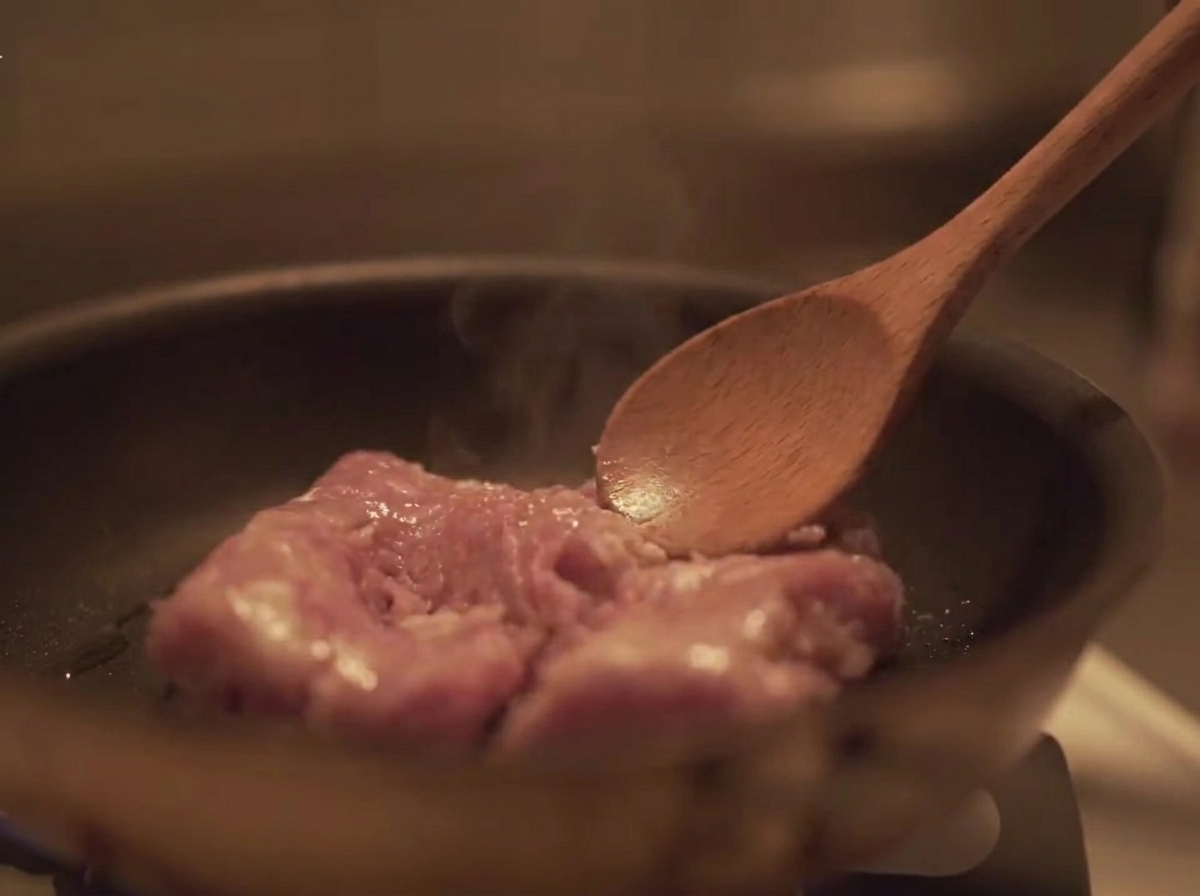 Hackfleisch wird in der Pfanne mit einem Holzlöffel umgerührt.