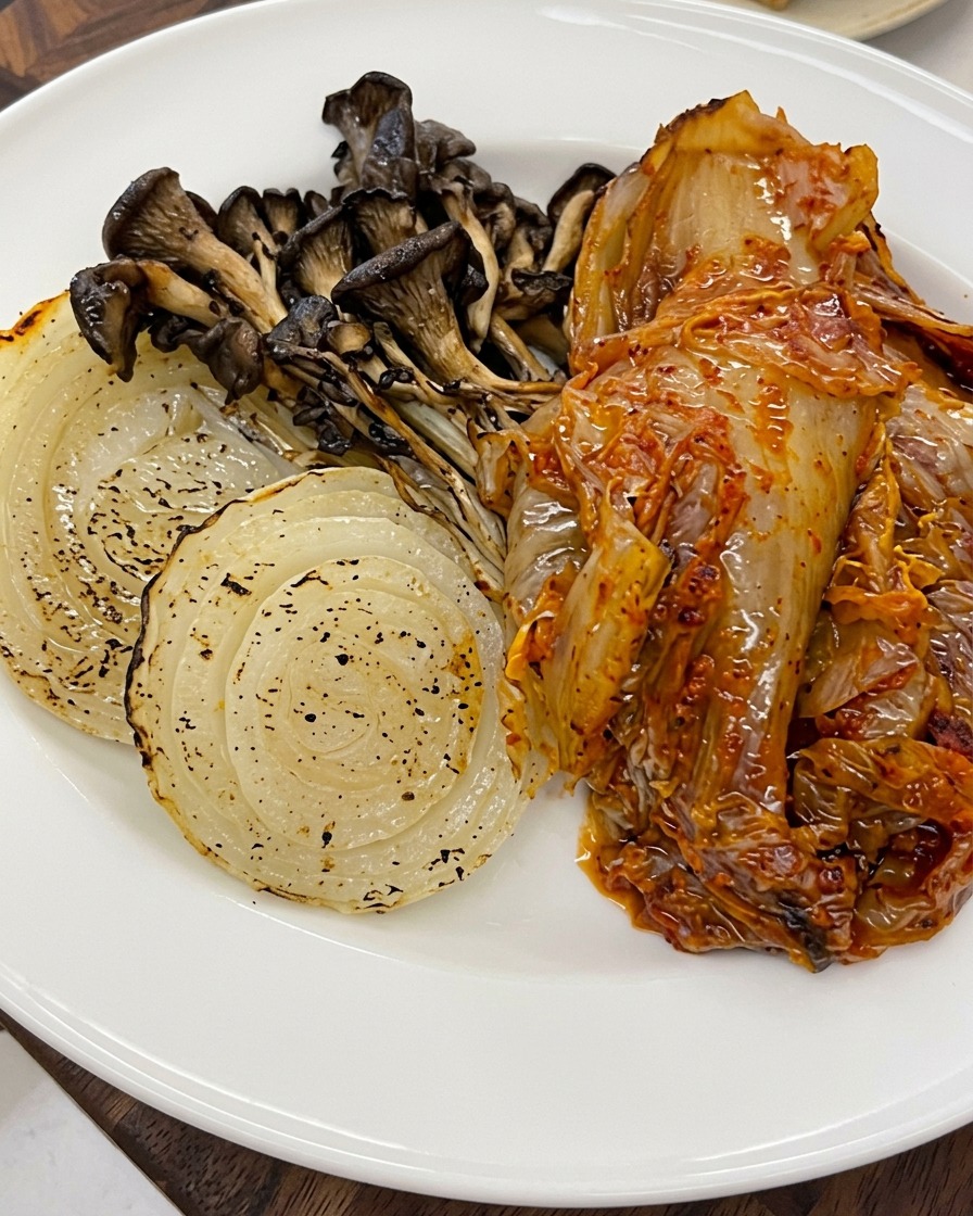 Sesamsamen, die über das geröstete Gemüse und Kimchi auf einem Teller gestreut werden.