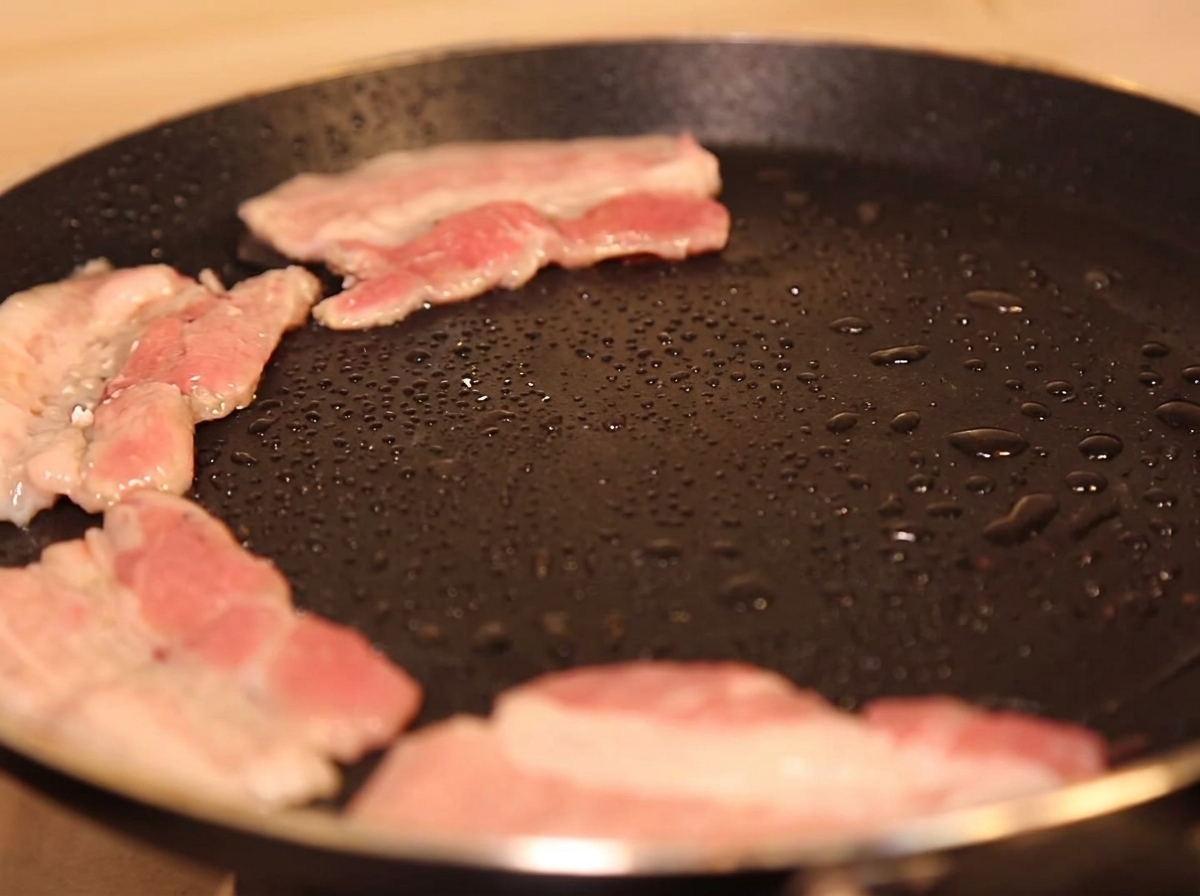 Schweinebauchscheiben braten in einer heißen Pfanne mit wenig Öl und beginnen zu bräunen.