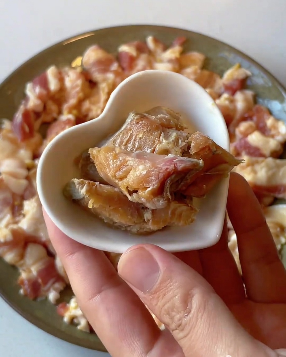 Stücke von gesalzenem Fisch auf dem Schweinefleisch.