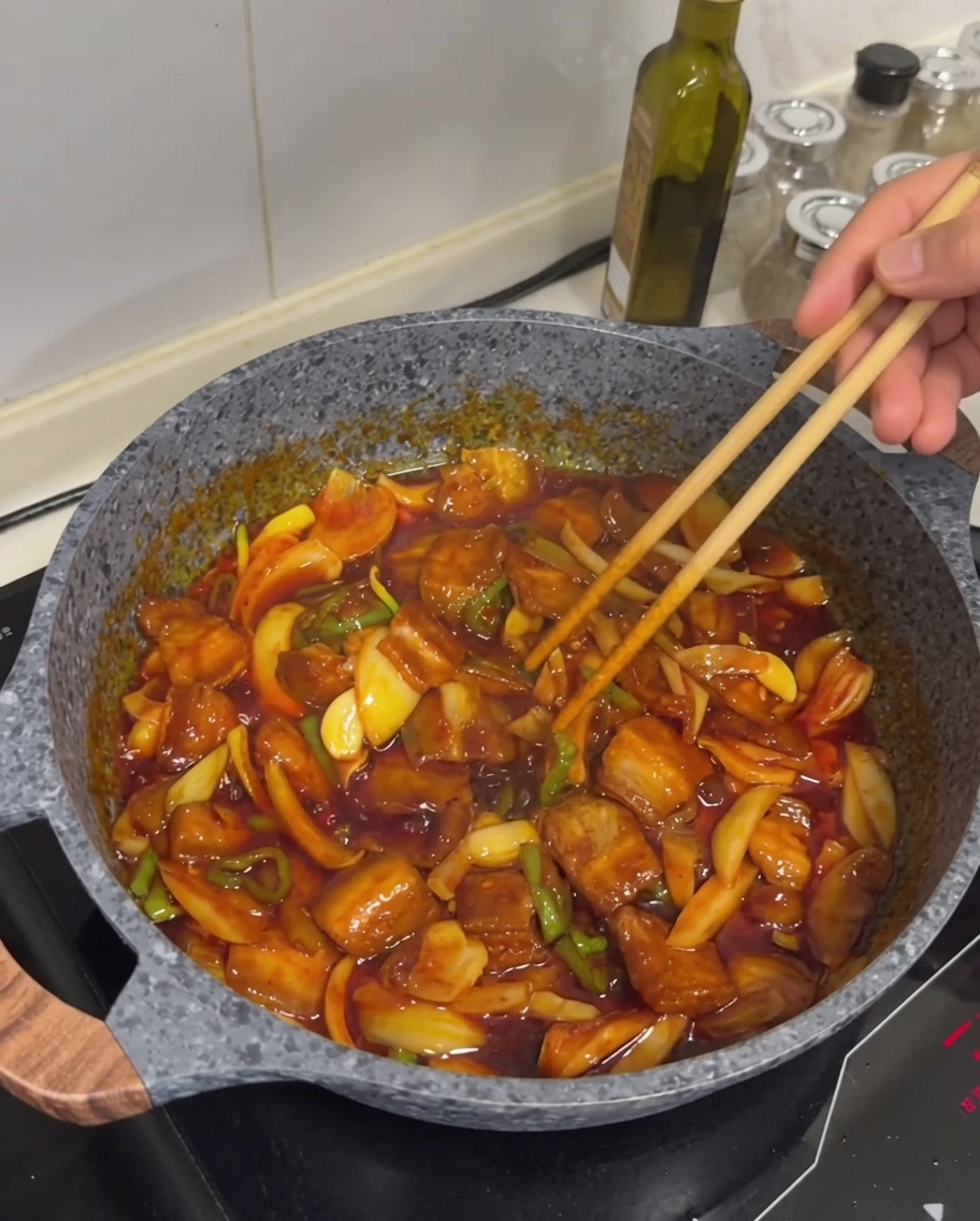 Das fertige Gericht mit goldbraunem Fleisch, glänzender Sauce und einer Prise weißem Sesam darauf.