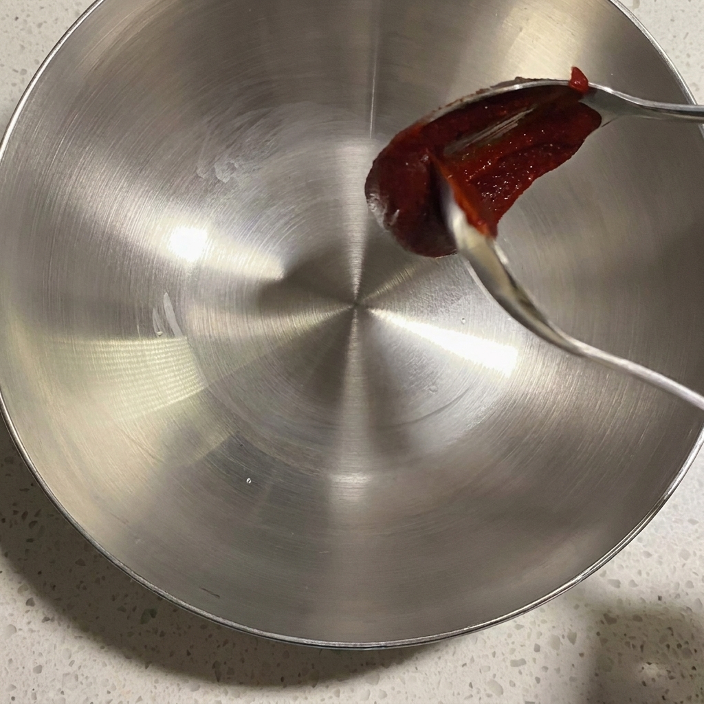 Eine Metallschüssel mit verschiedenen Saucen und Gewürzen für die Marinade.