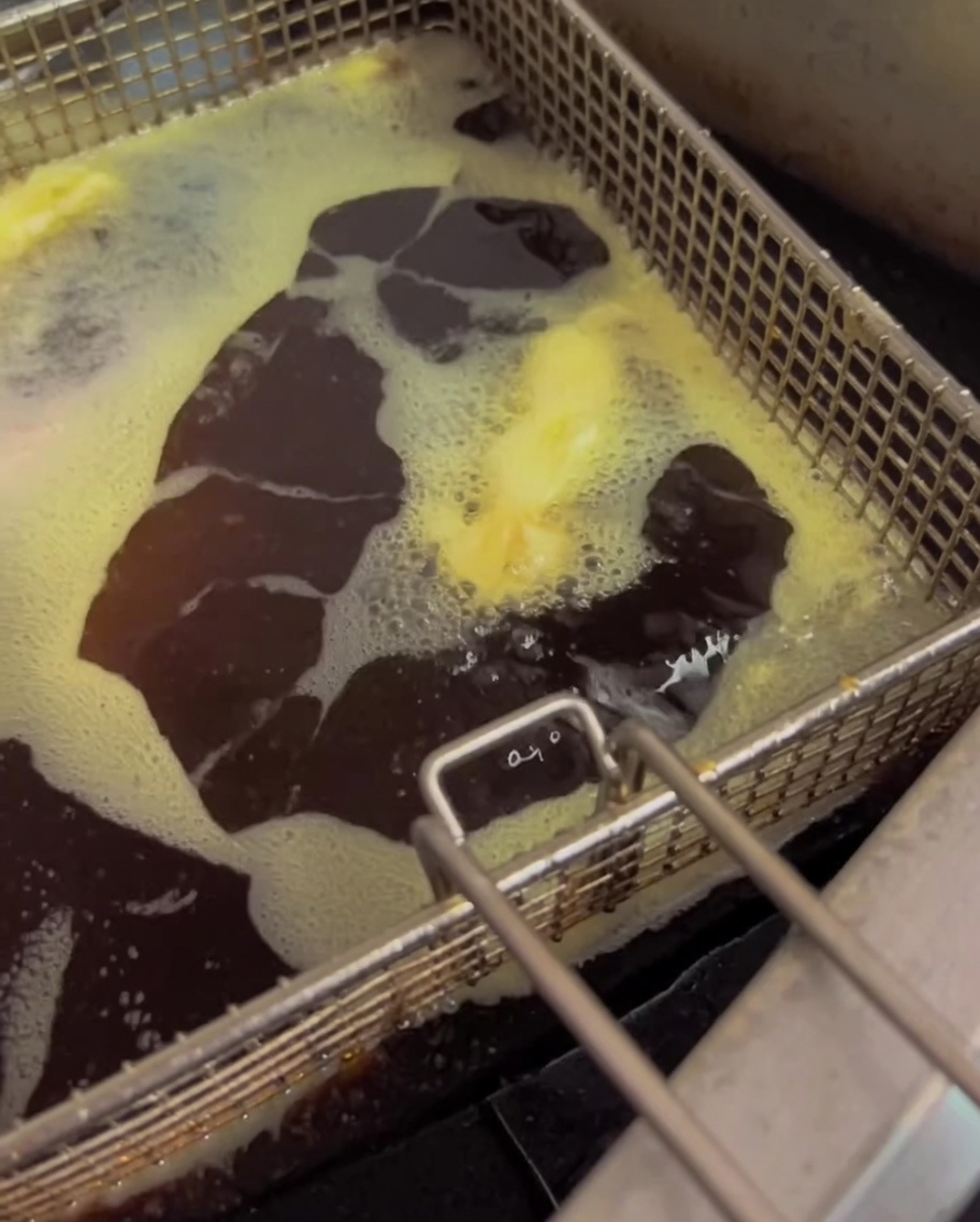 Grüne Bohnen frittieren in heißem Öl in einer Fritteuse.