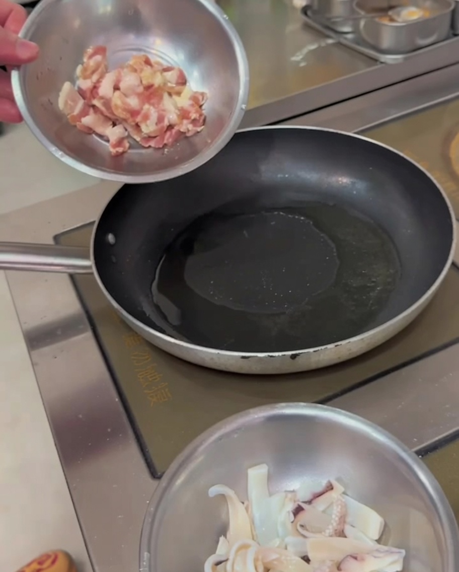 Schweinebauchstreifen braten in einer heißen Pfanne und zeigen goldbraune Ränder.